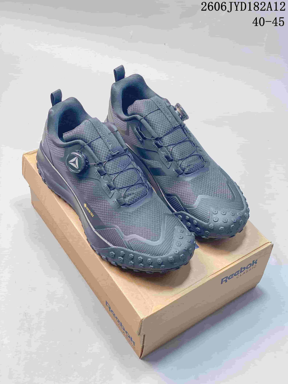 Pair of charcoal Reebok Workout Plus RC 3.0 sneakers on a Reebok Classic box.