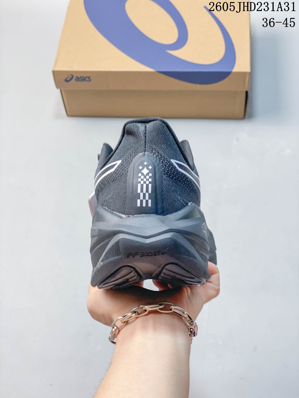 Rear view showing the heel and sculpted midsole of a dark gray running shoe