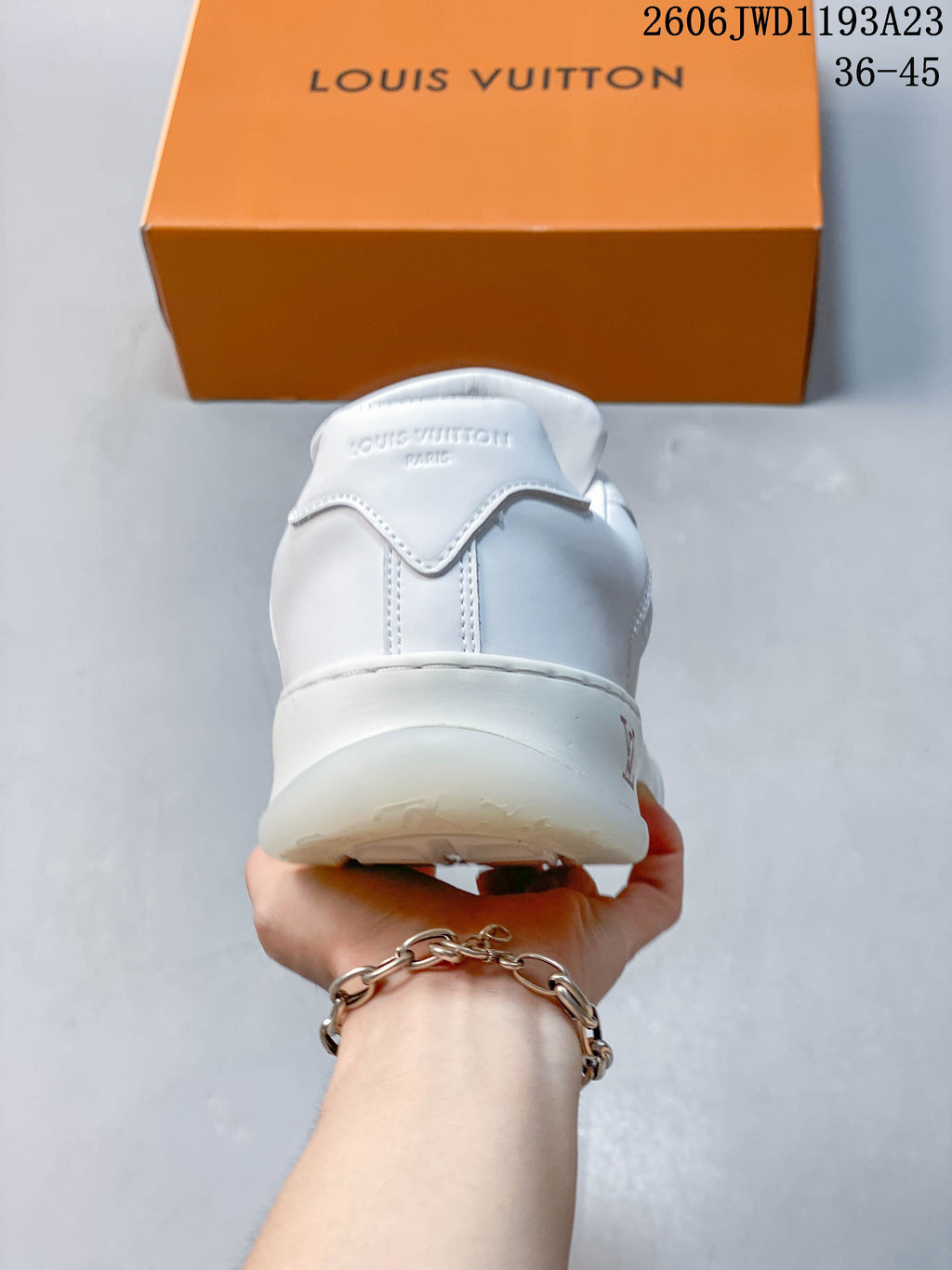Rear view of a white low-top sneaker with stitched heel panel