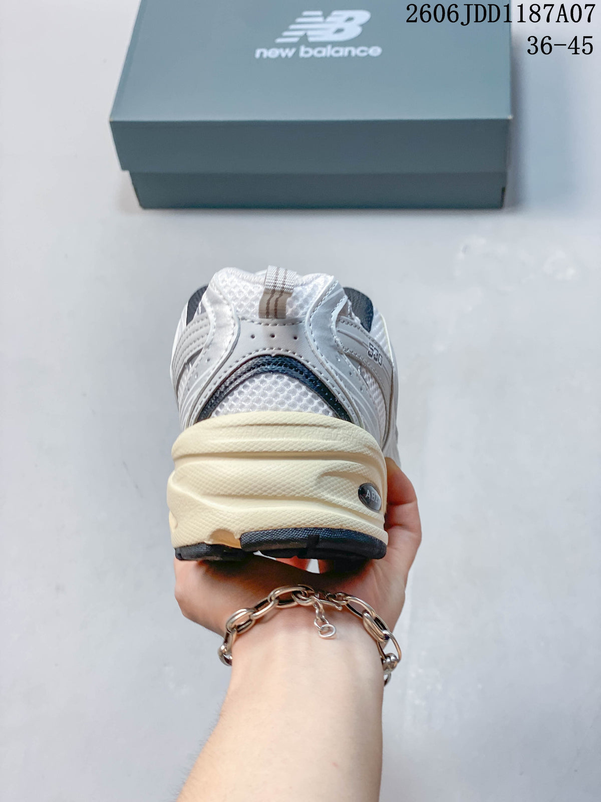 Rear view of a white and grey New Balance 530 sneaker with a cream-colored midsole