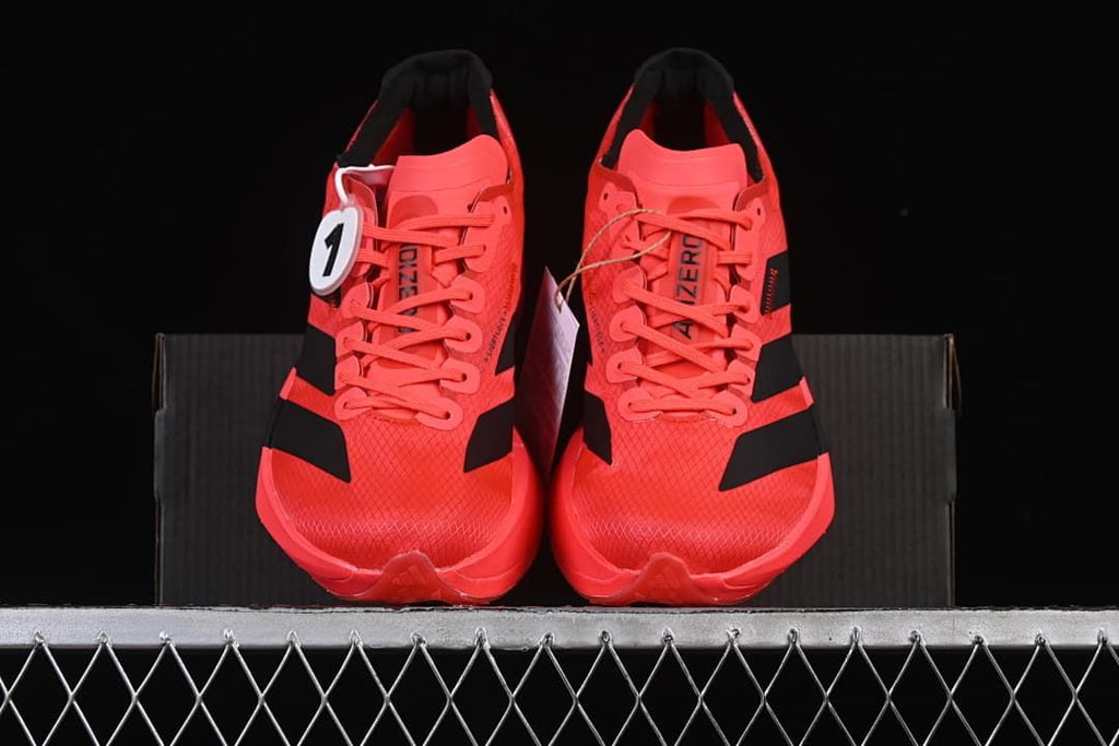 Front view of the pair of coral lace-up running shoes