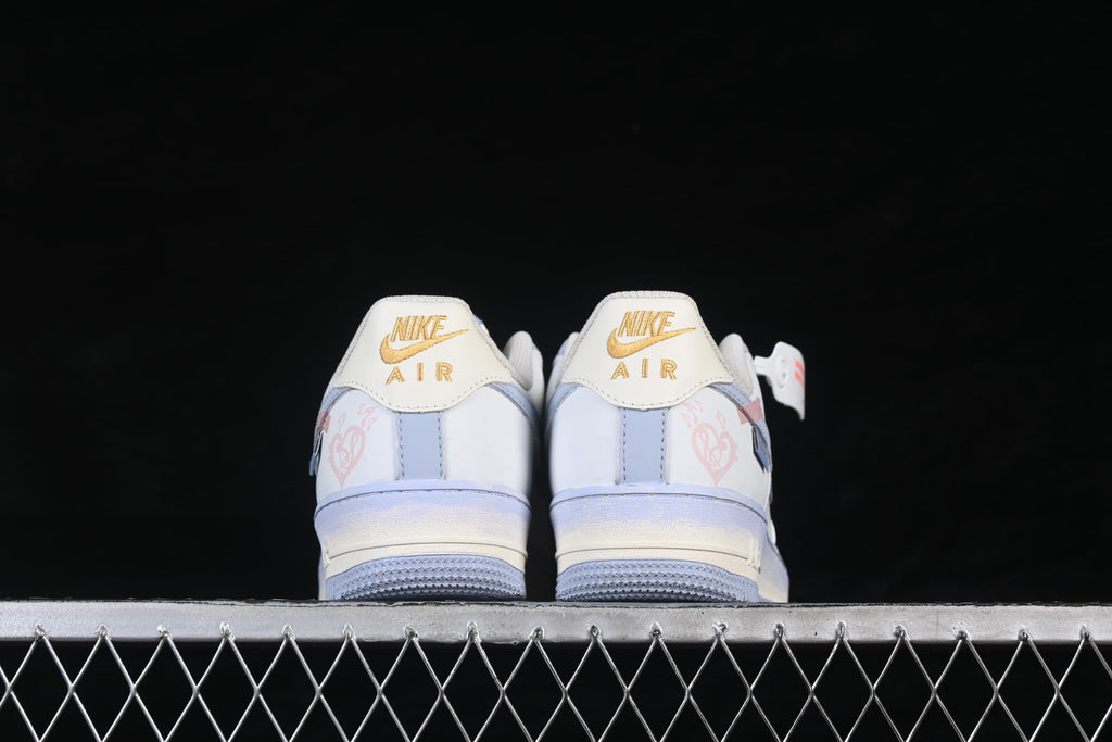 Rear view of both sneakers with gold heel branding and pale blue soles