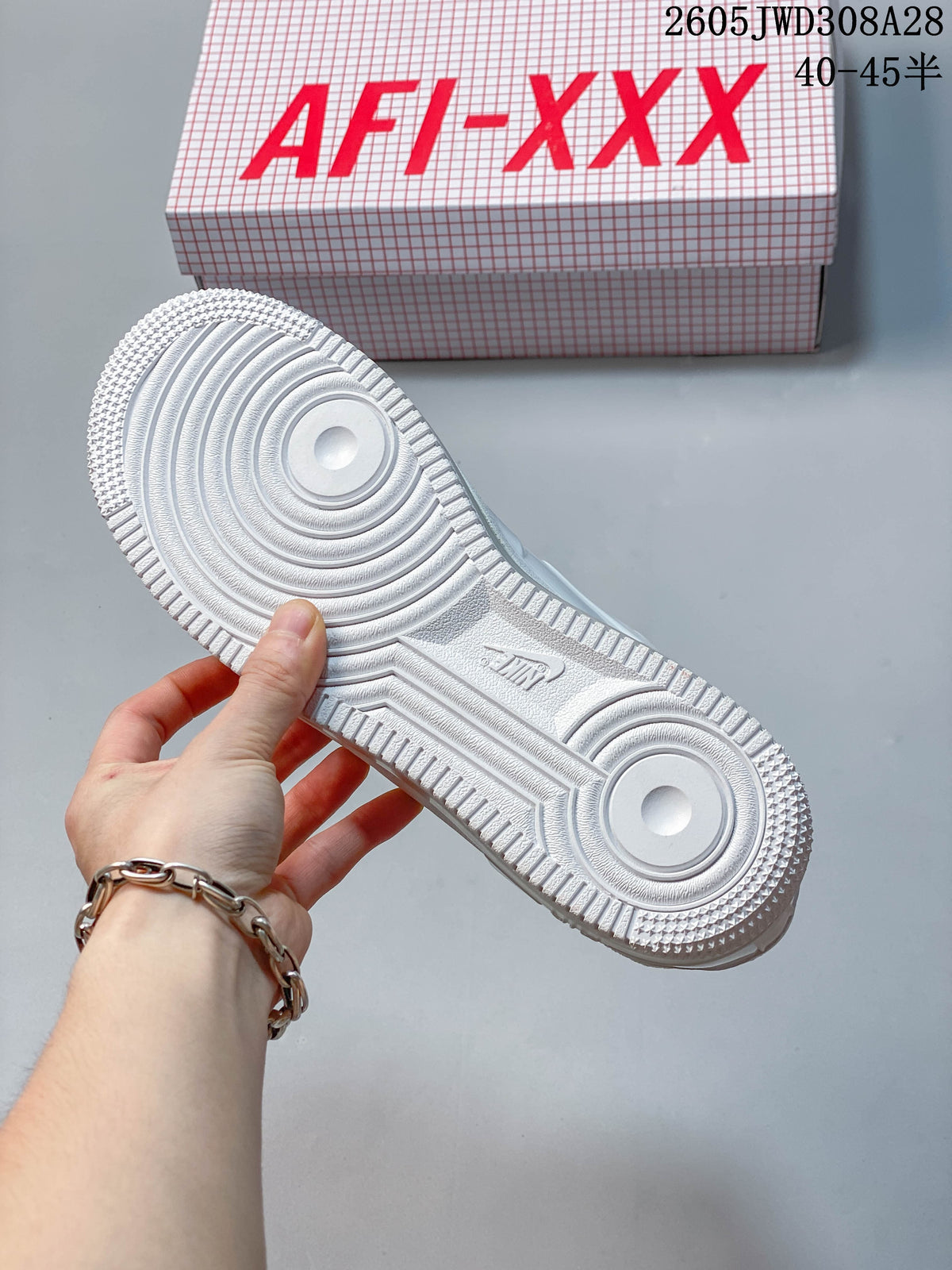 Underside of a white sneaker showing the tread pattern