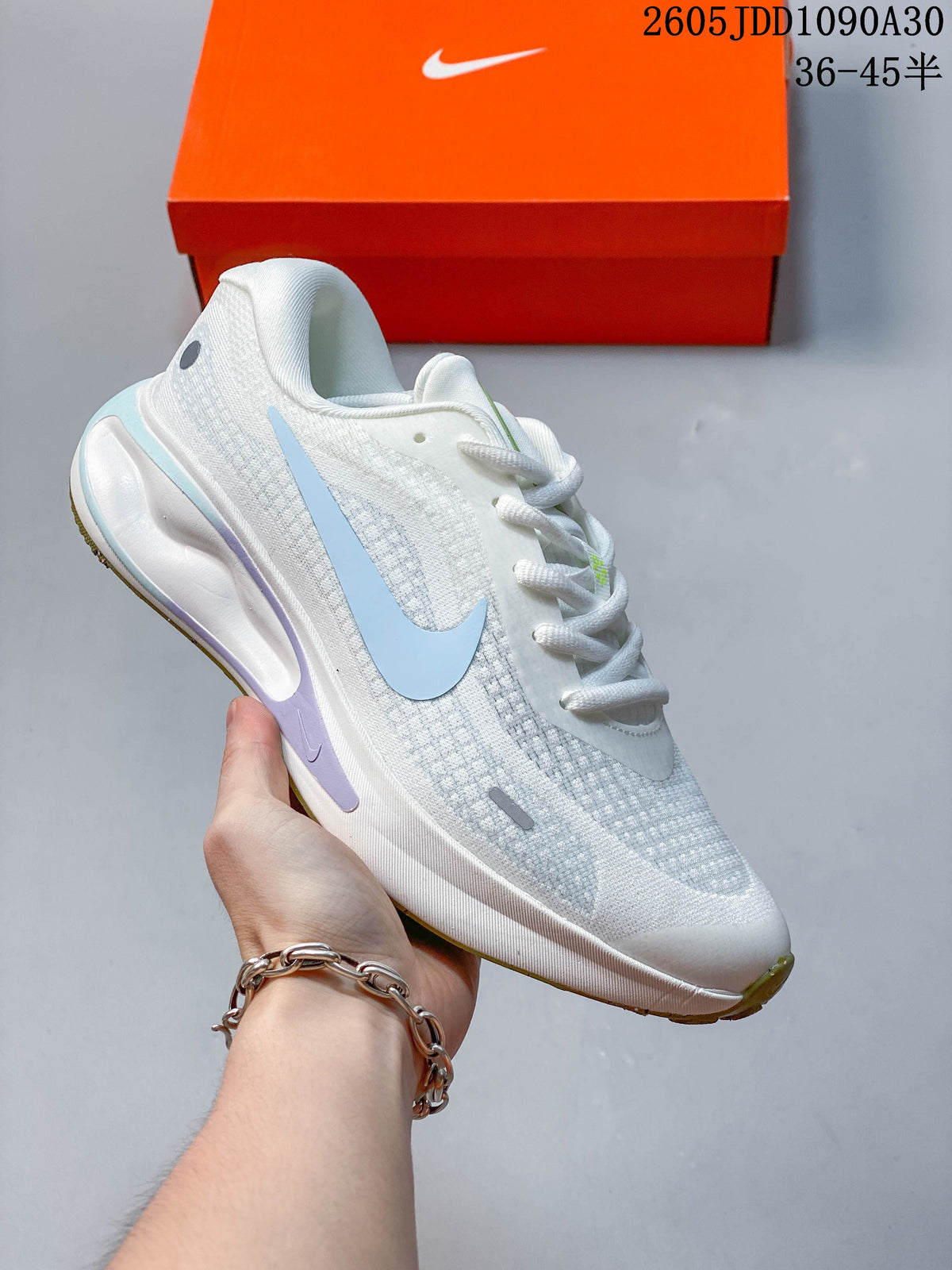 White Nike Journey Run running shoe with pink and navy accents.