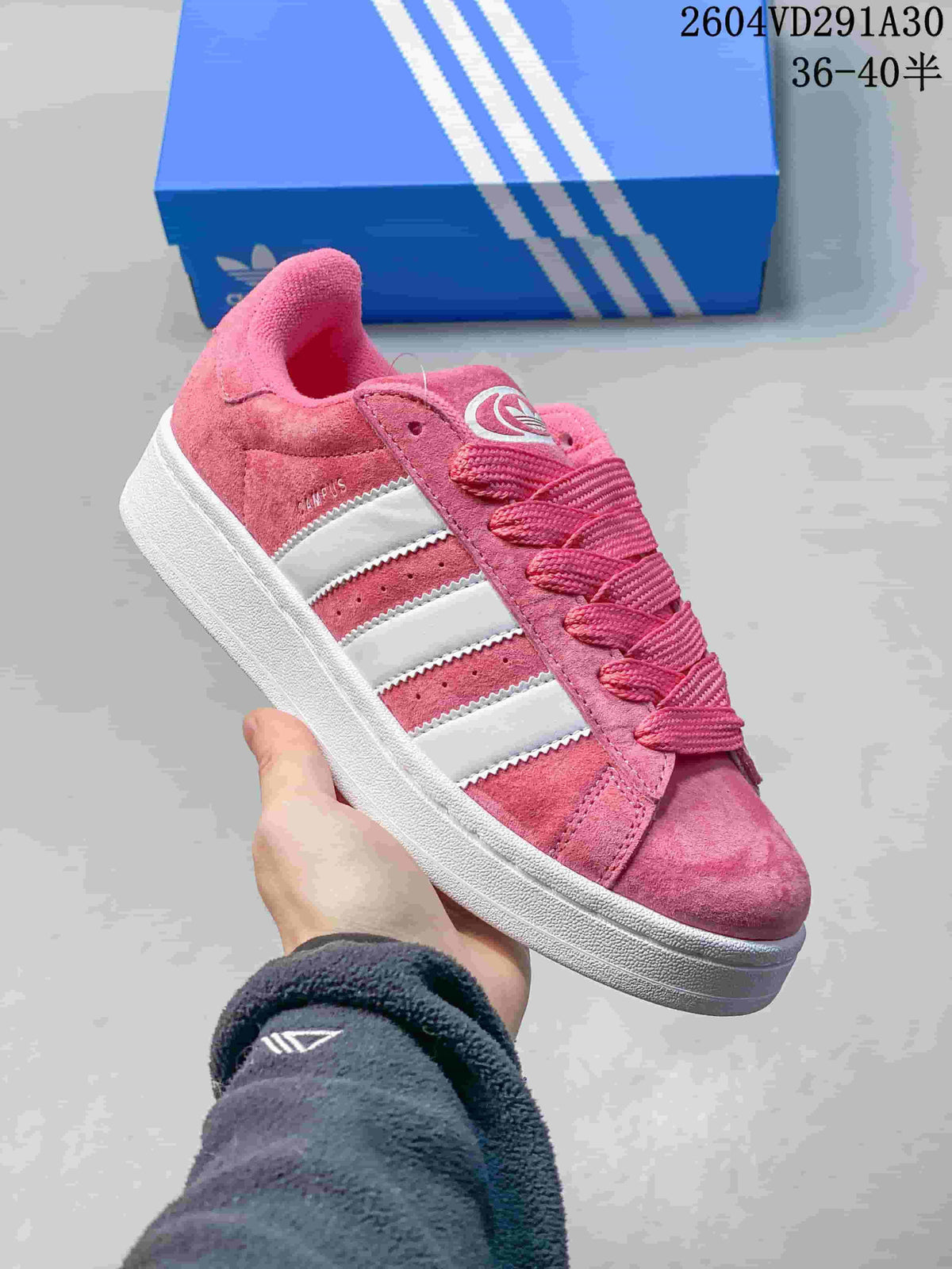 Close view of a pink Adidas Campus sneaker with white stripes and a white sole.