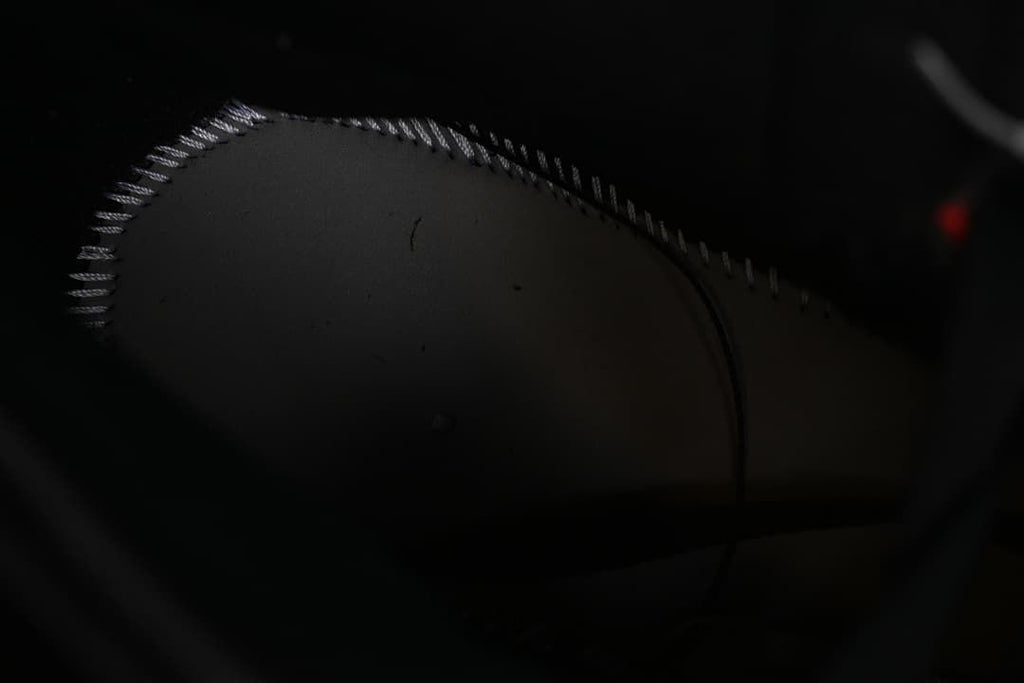 Dark close-up of stitching on the shoe interior