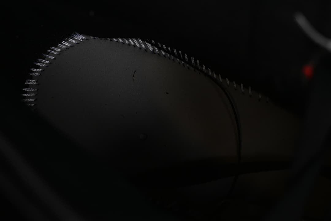 Dark close-up of stitching on the shoe interior