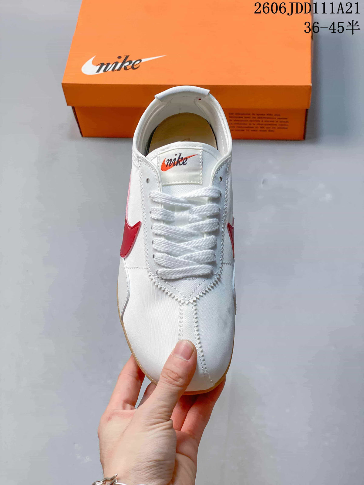 Top view of a white lace-up sneaker with red side accents