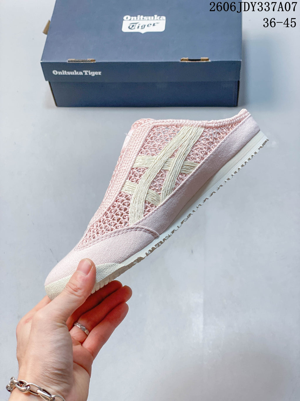 Side profile of the pink slip-on shoe with cream stripes