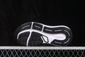 Bottom view of black and white Nike running sneakers showing the segmented rubber outsole and traction pattern.