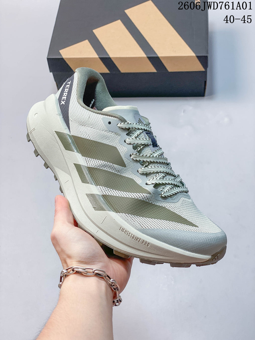 Light green and gray Adidas Terrex trail running shoe with dark stripes and a lugged outsole