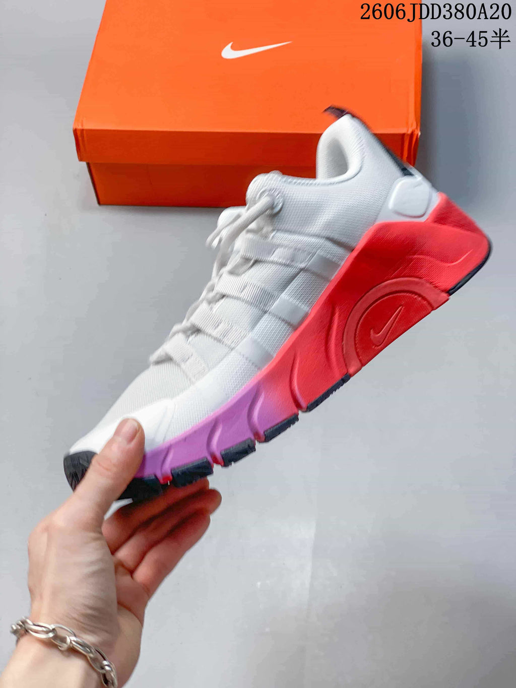 Side view of the white Nike Free Metcon 7 with coral-red and purple sole accents.
