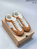 Brown and white Descente low-top sneakers shown on a shoe box