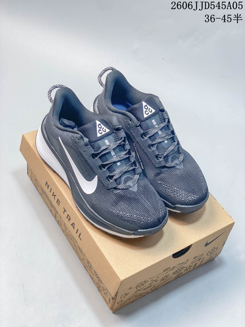 Charcoal Nike Pegasus Trail 6 shoes with white swooshes on a box