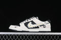 Nike SB Dunk Low in black and off-white with a daisy-patterned Swoosh and yellow accents