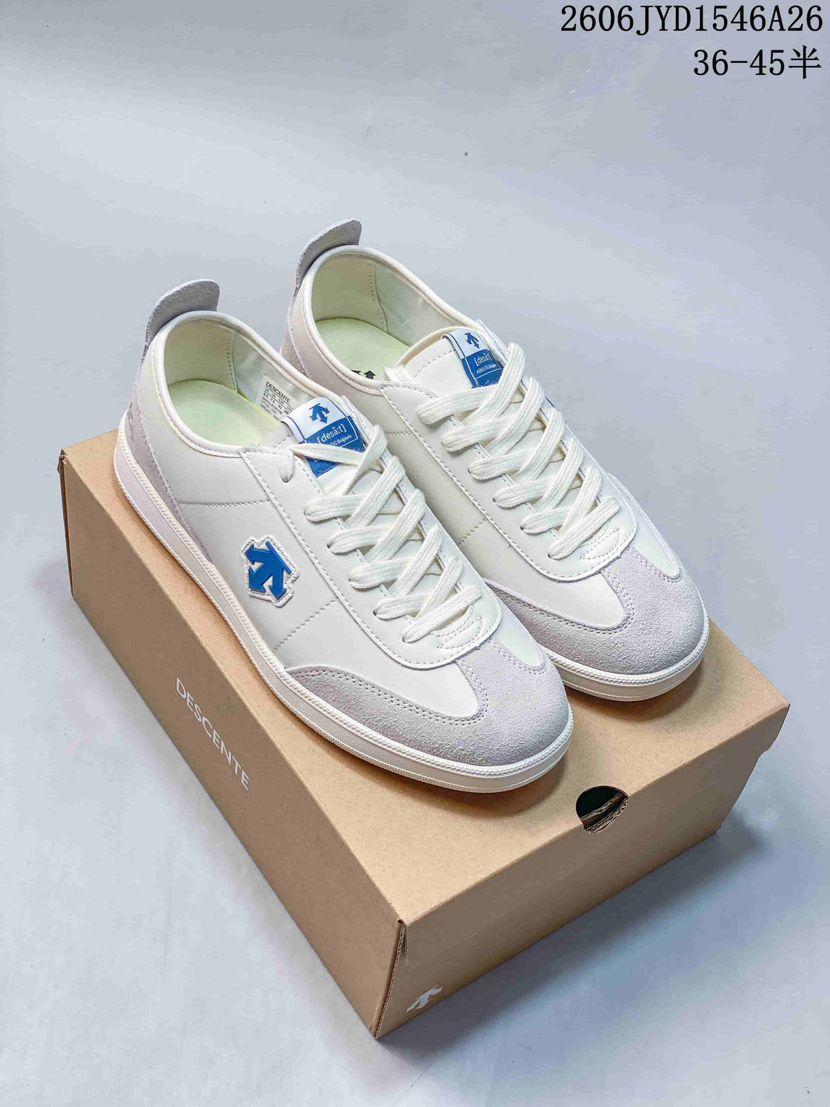 White and light gray Descente low-top lace-up sneakers displayed on a shoe box.