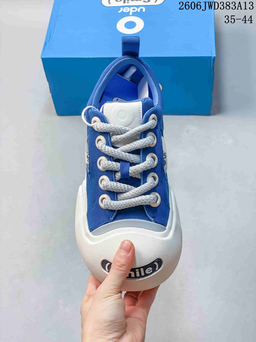Front view of the sneaker showing its white laces, rounded toe bumper and smile detail.