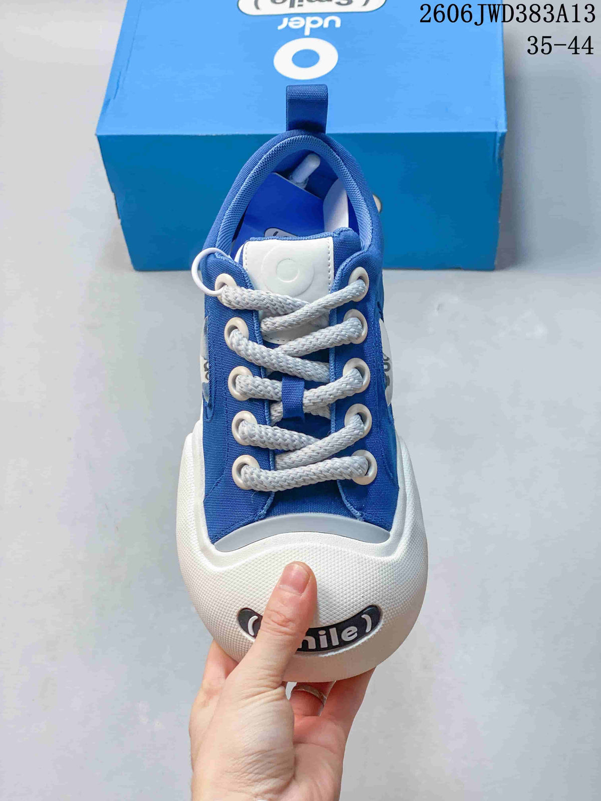 Front view of the sneaker showing its white laces, rounded toe bumper and smile detail.