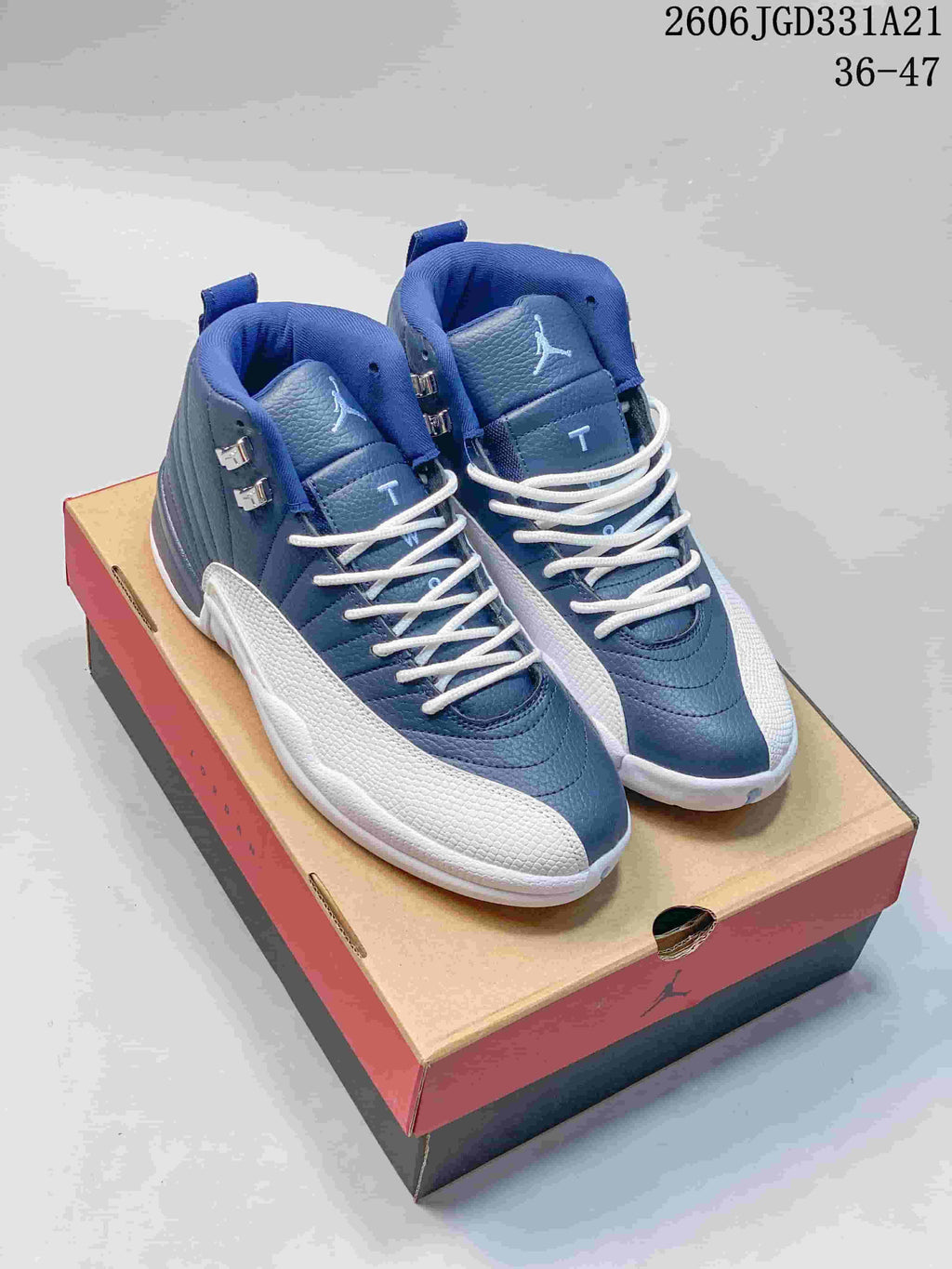 Blue and white high-top Air Jordan 12 shoes displayed on a shoe box
