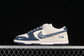Side view of a cream and navy low-top sneaker with a patterned Swoosh and contrast stitching.