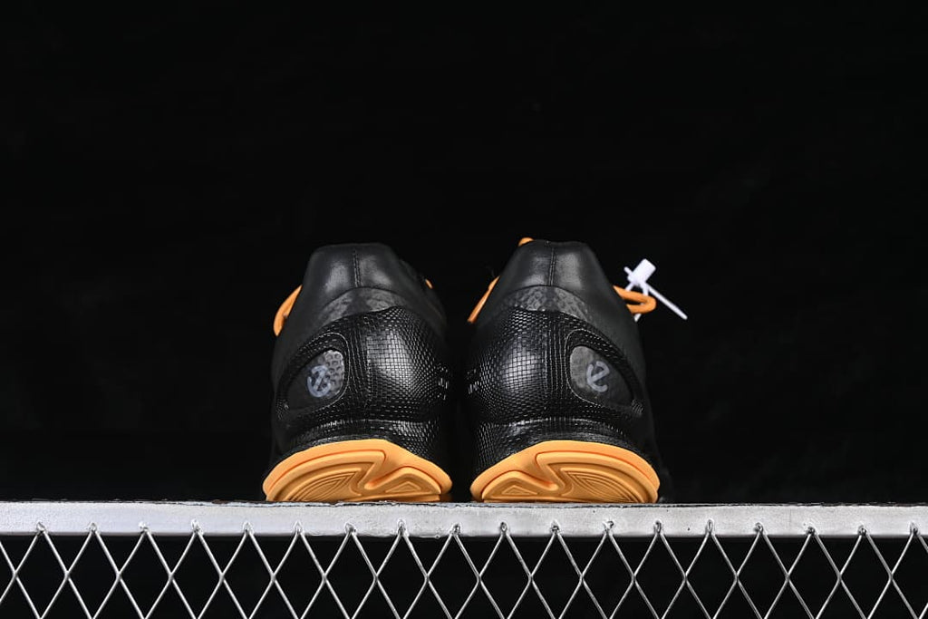 Rear view of the pair showing black heel panels and orange outsole details