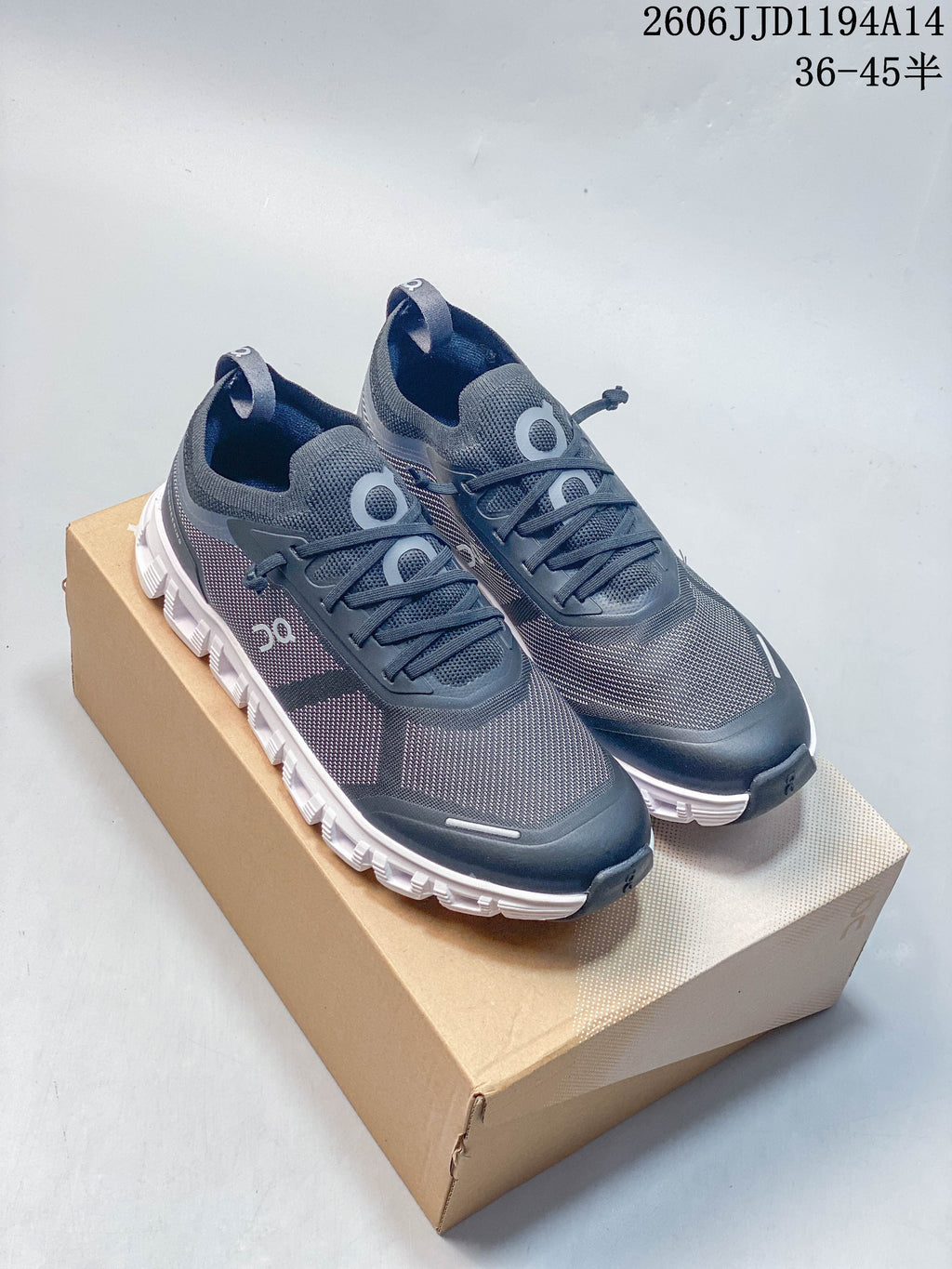 Pair of dark gray On Cloud 6 Versa shoes with contrasting white soles