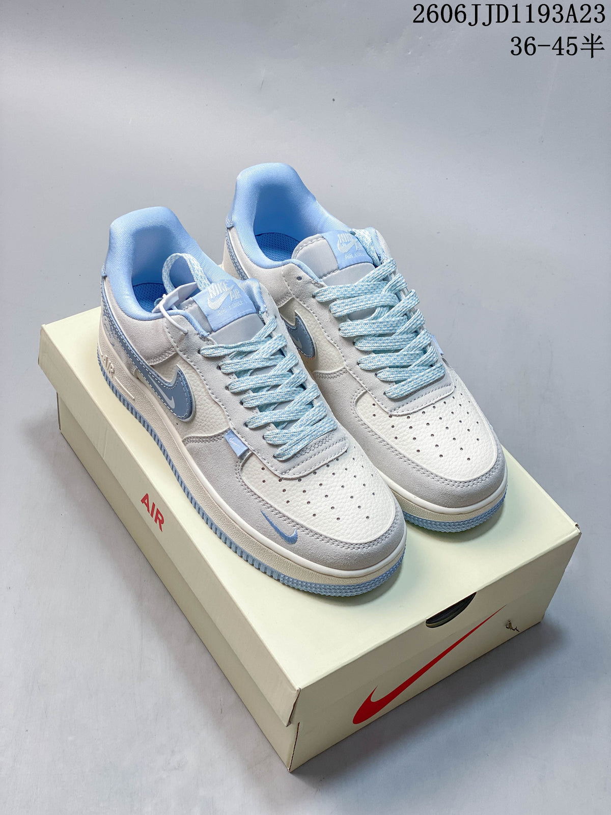 White and ice-blue low-top sneakers shown from above on a shoebox