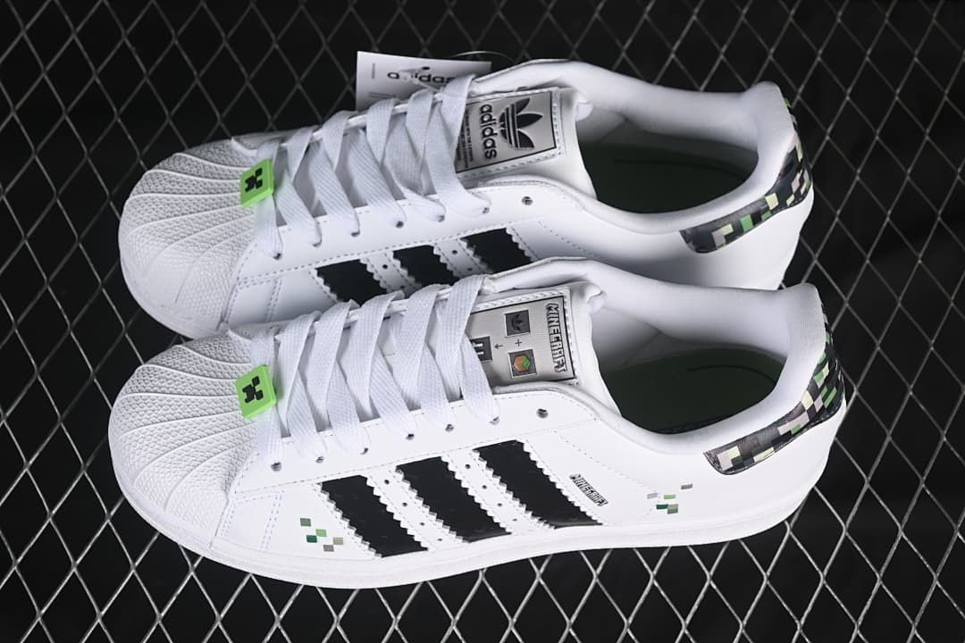 Pair of white adidas Superstar II J sneakers with black stripes and Minecraft-inspired details