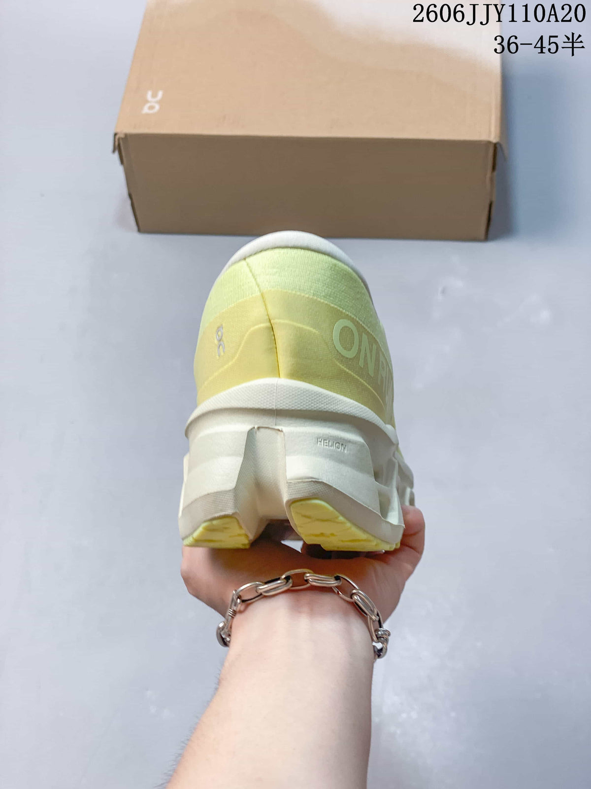 Rear view of the pale yellow running shoe, showing the heel and sculpted sole.