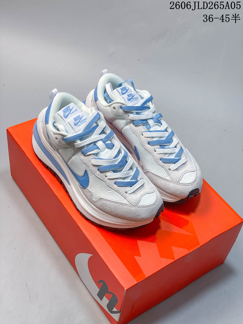 Pair of light-colored Nike Sacai LDWaffle sneakers with blue accents, shown from above