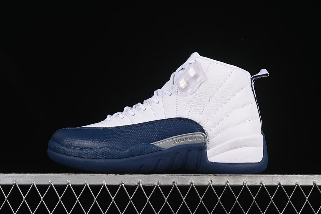 Side view of a white and navy Air Jordan 12 Retro sneaker