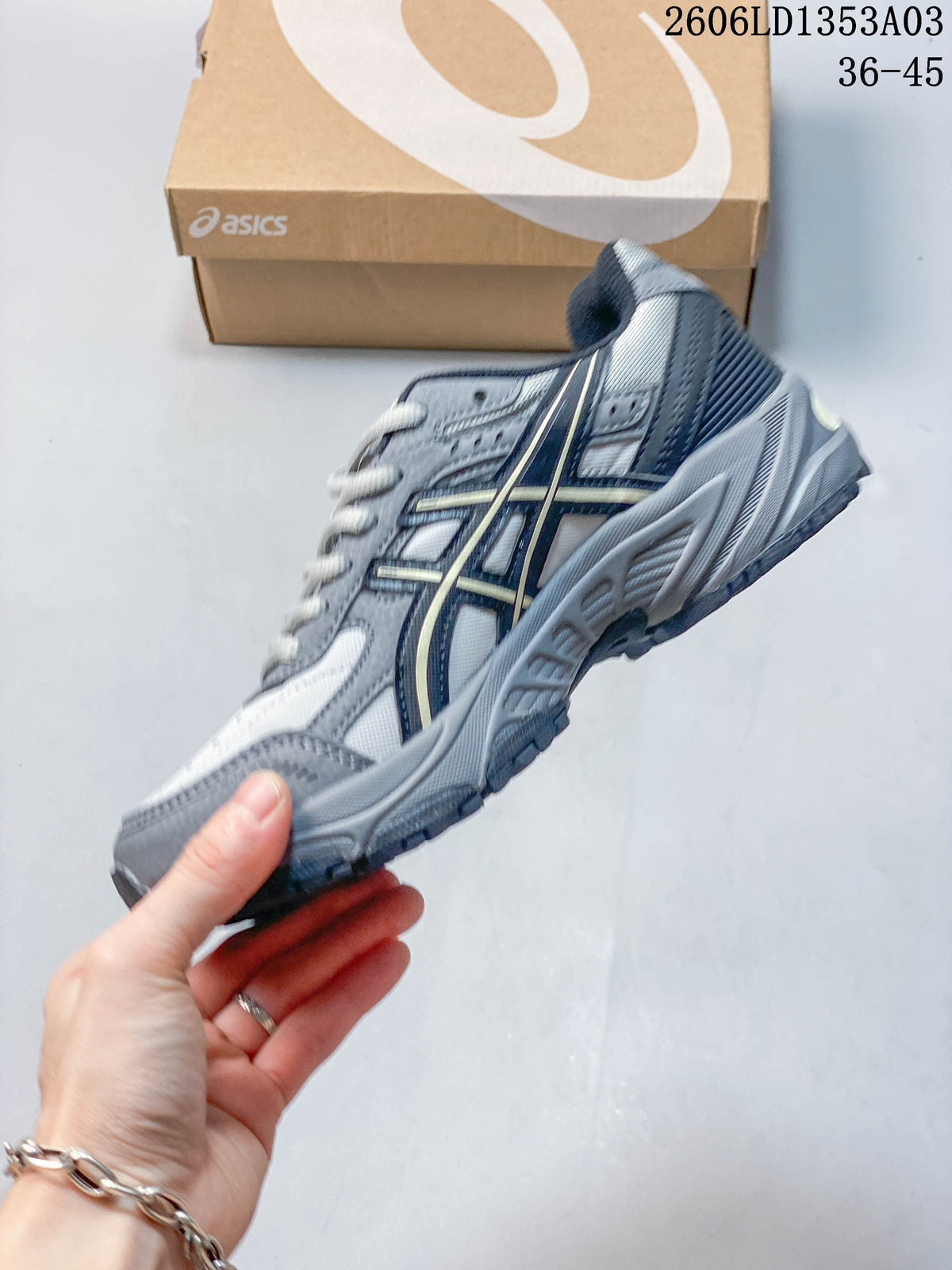 Side view of the grey ASICS GEL-170TR sneaker with contrasting side stripes.