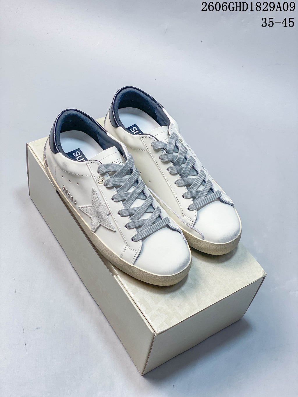 Pair of white Golden Goose Super-Star style low-top sneakers with gray laces and star detail