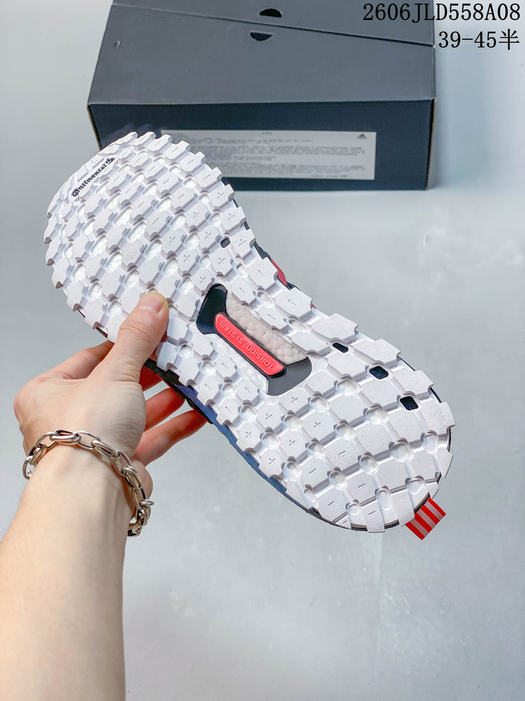 Underside of the shoe showing a white lugged outsole and a Torsion System marking