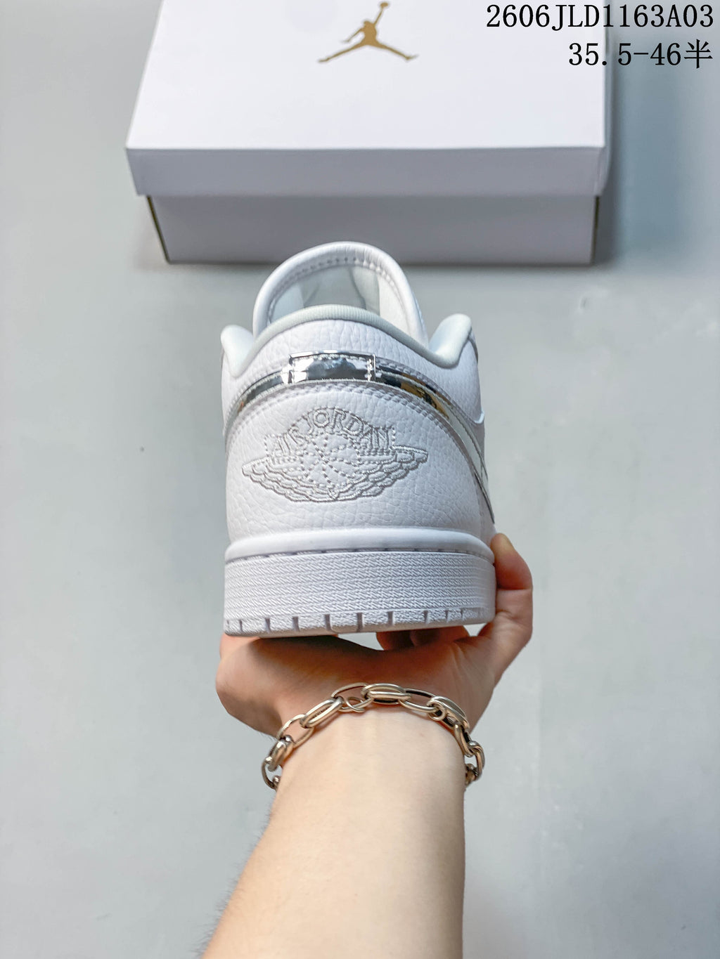 Rear view of a white Jordan Air Jordan 1 SE low-top sneaker, showing the heel detail and outsole.