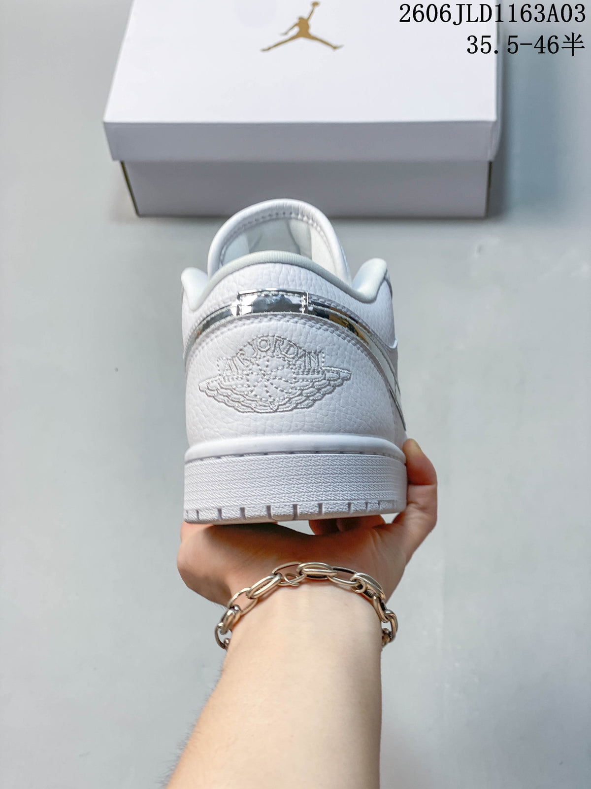 Rear view of a white Jordan Air Jordan 1 SE low-top sneaker, showing the heel detail and outsole.