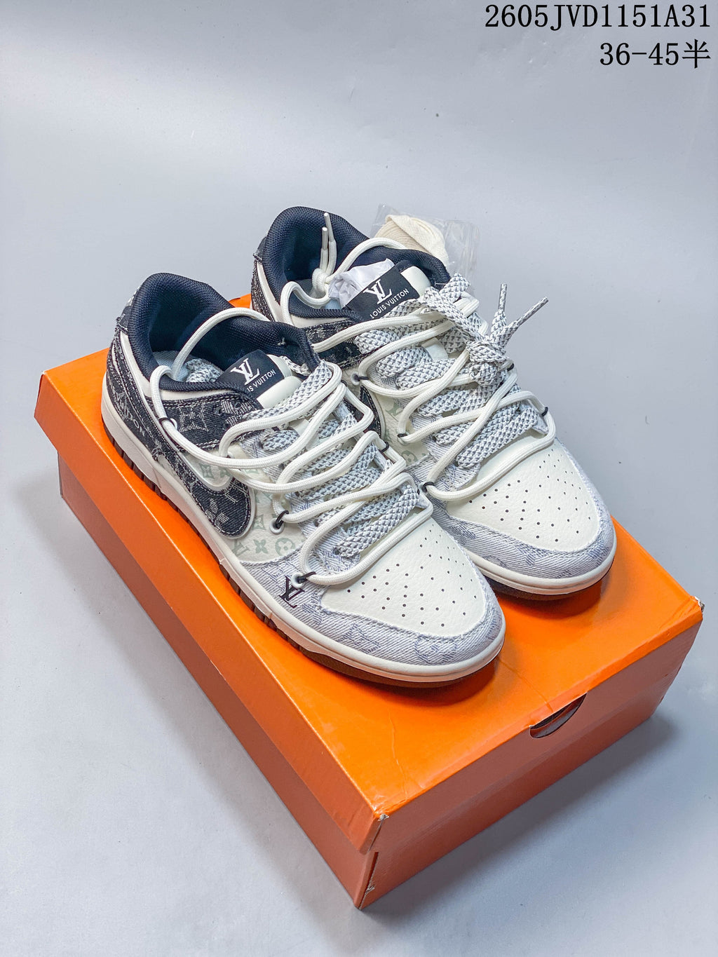 Pair of cream low-top sneakers with gray patterned overlays, dark collars, and layered lace detailing.