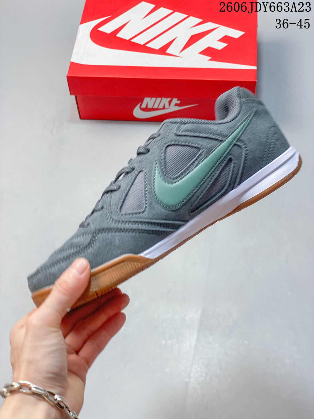 Side profile of a gray Nike Gato sneaker with a sage-green Swoosh and gum outsole