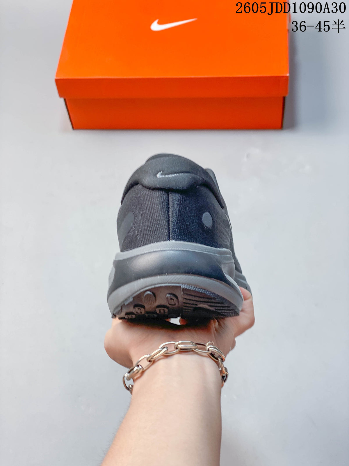 Rear view of a dark gray Nike Journey Run shoe showing the heel and outsole.