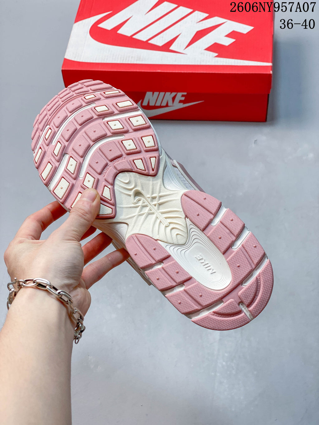 Underside of a pink and white Nike V5 RNR sneaker showing the tread pattern