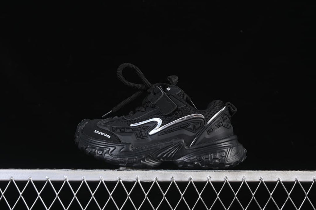 Black children's sneaker shown in side profile with silver-tone accents.