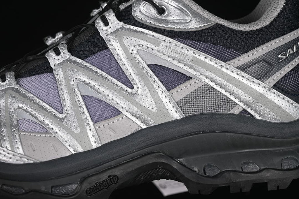 Close-up of layered silver side overlays and rugged outsole