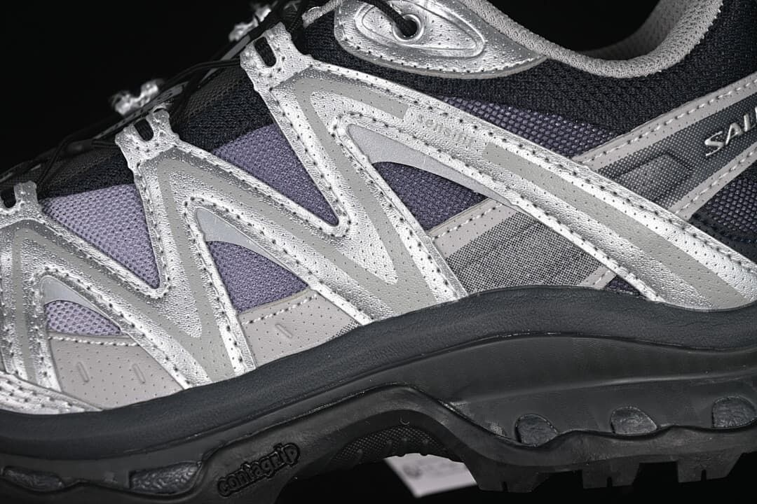 Close-up of layered silver side overlays and rugged outsole