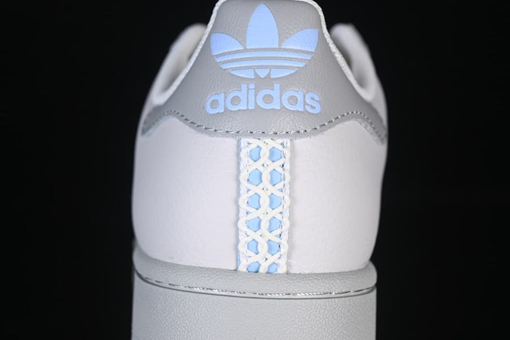 Rear view showing grey heel panels, pale blue Trefoil branding and patterned heel stripe.