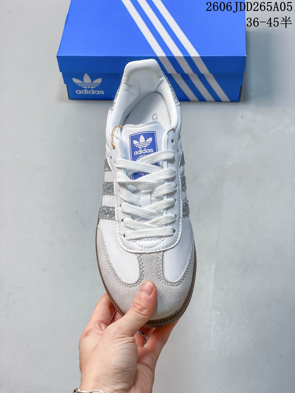 Top view of a white Samba OG sneaker with lace-up closure and gray toe overlays.