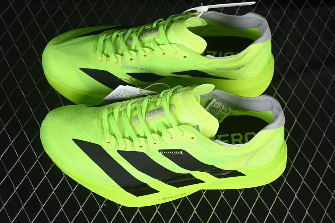 Pair of lime green running shoes with black stripes