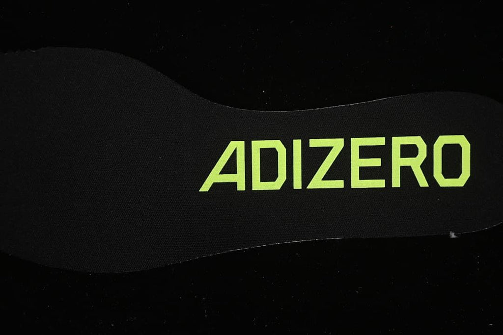 Close-up of the black insole with lime Adizero lettering.