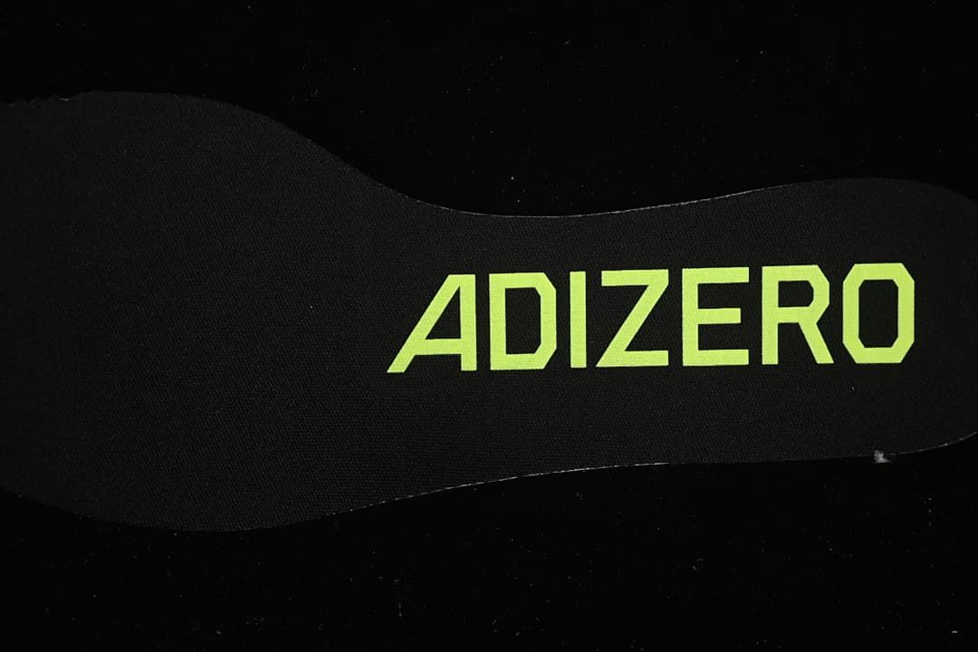 Close-up of the black insole with lime Adizero lettering.