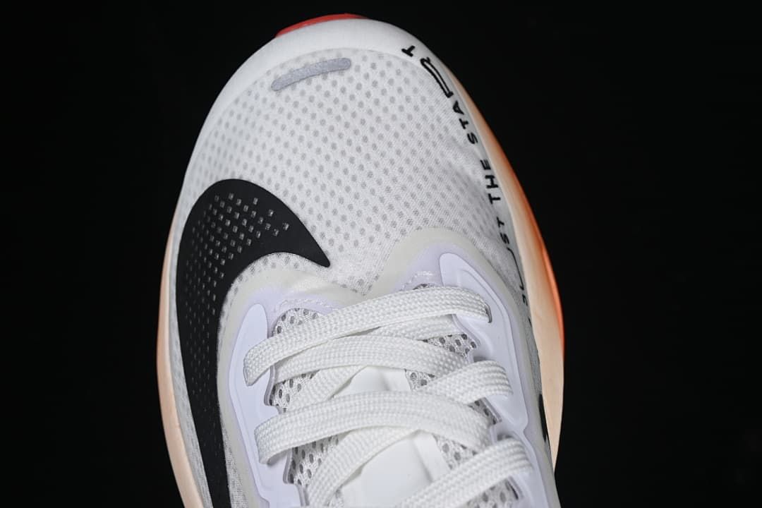 Top view of the shoe's perforated toe, laces and black Swoosh