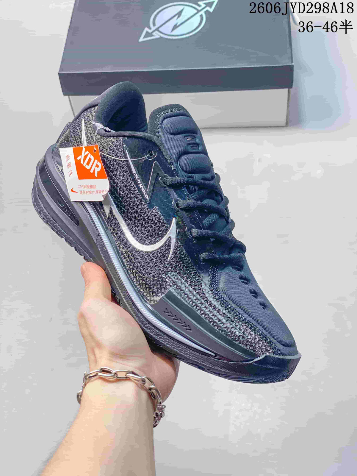 Dark gray Nike Air Zoom GT Cut low-top shoe with silver-toned details and a hanging tag.